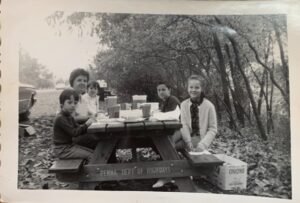 An old family photo of my mom enjoying a picnic with her loved ones, cherishing simple moments together