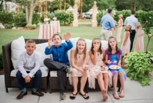 Young kids enjoying a moment at a wedding with a beautiful backdrop.