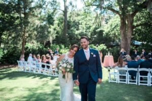 Wedding day photo of the business owners in front of white folding chairs