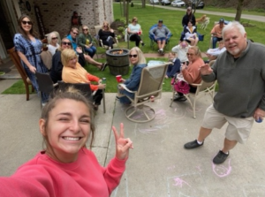 Large family gathering selfie around a fire on Easter Day, enjoying time together outdoors